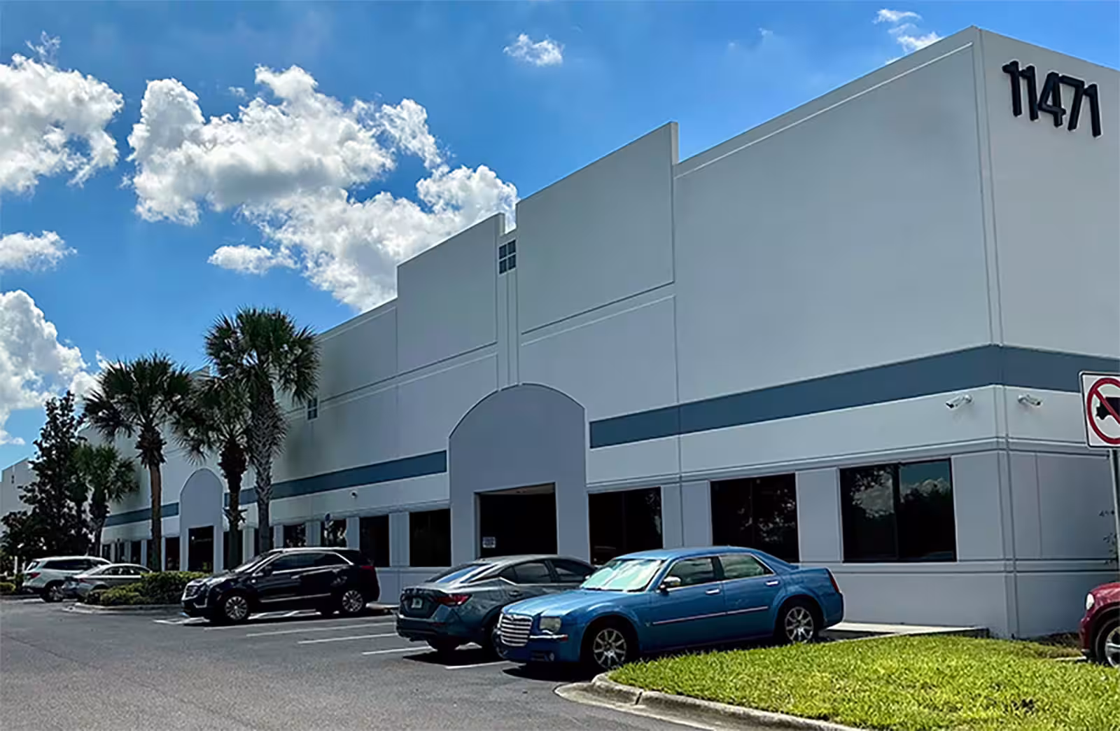 Building 11471 at New Tampa Commerce Center with cars parked along the front.