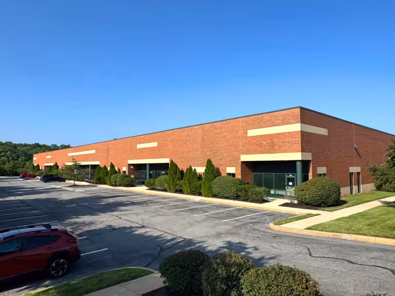 Red-brick building in the Philly Interstate Light Industrial Portfolio beside its parking lot.